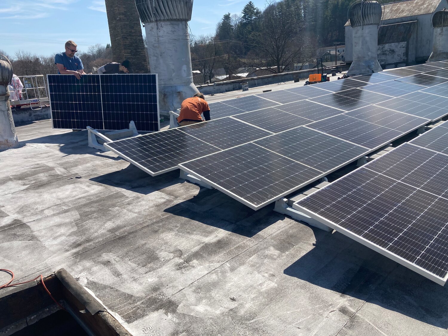 The last of 82 solar panels is mounted on the roof of the Ritz Company Playhouse in Hawley.